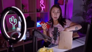 Steuern für Streamer, Influencer und Creator erklärt. Frau am Schreibtisch mit Controller und Giftbag