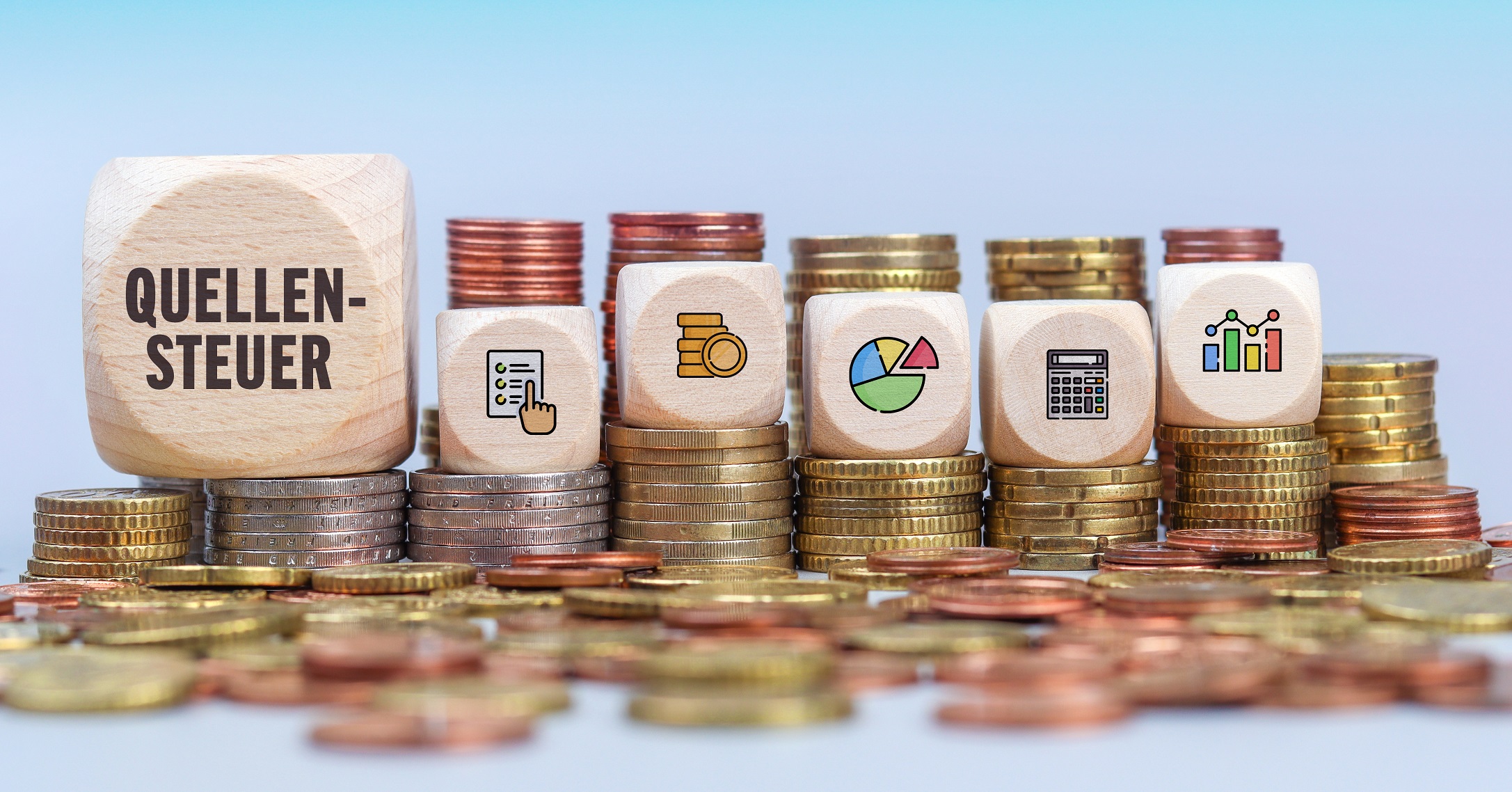 Quellensteuer nach § 50a EStG. Münzstapel mit Holzwürfeln. Text und Icons auf Würfel